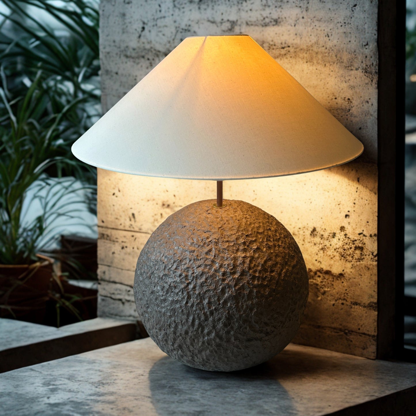 Table lamp with textured base and white shade on a concrete surface