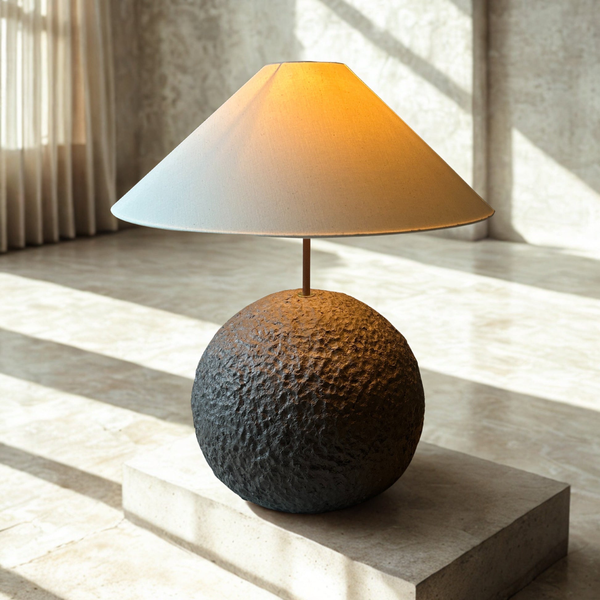 Table lamp with textured base and white shade on a light wooden surface
