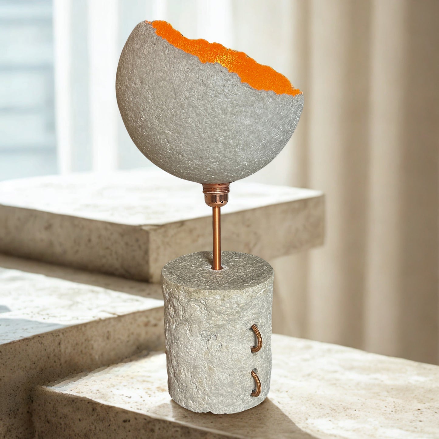 Decorative object with a textured surface and orange top on a concrete surface.
