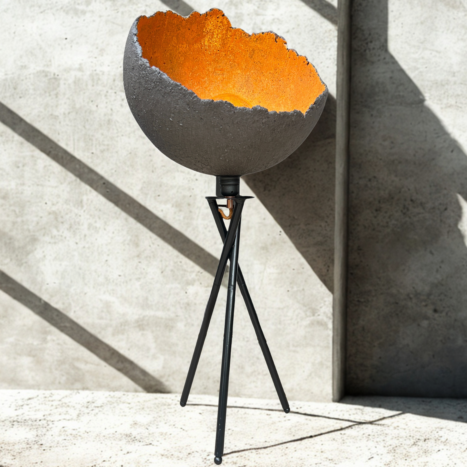 Modern floor lamp with a rusted metal shade against a concrete wall.